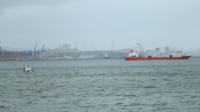 Big loaded cargo ship swims ashore of the Istanbul port. Transportation, high seas, profession. Cityscape, industrial shipyard