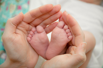 Obraz na płótnie Canvas baby foot and mother hands