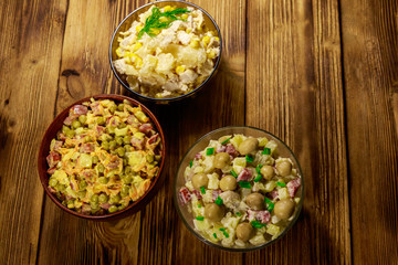 Set of festive mayonnaise salads on wooden table