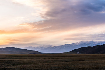 Naklejka na ściany i meble Snow Mountain Scenery of Bayinbrook Grassland in Xinjiang ，when the sun goes down