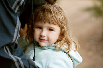 portrait of smiling little girl, small cheerful girl in coat holding to her father - 257802352