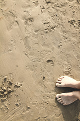 Fototapeta na wymiar Feet standing on wet disturbed sand
