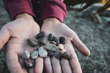 Child’s young hands holding colorful pebbles