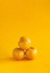 Yellow plums on a yellow background