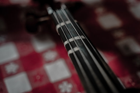 Neck of violin with red checkered background