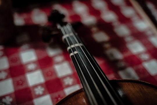 Neck of violin with red checkered background