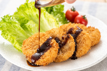 コロッケにソースをかける