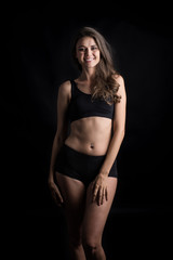 Fototapeta na wymiar Beautiful woman with healthy body on black background