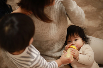 Obraz na płótnie Canvas 赤ちゃんにミルクを与える親子