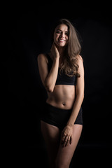 Fototapeta premium Beautiful woman with healthy body on black background