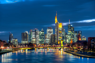 Fototapeta premium Panoramę centrum Frankfurtu z wieżowcami widzianymi wieczorem nad Menem