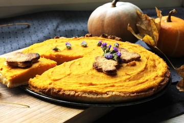 Pumpkin Pie with whipped cream and cinnamon on rustic background, top view. Homemade pastry for Thanksgiving traditional Pumpkin Pie.