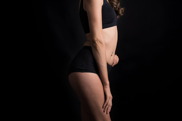 Fototapeta premium Beautiful woman with healthy body on black background