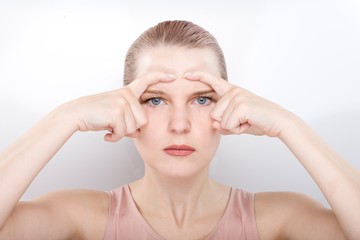 Naklejka premium facial gymnastics. the girl does massage and rejuvenating exercises for the face