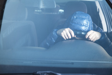 Hooded Man holding steering wheel. Driving car