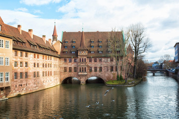 Heilig-Geist-Spital (Hospice of the Holy Spirit) in Old Town Nuremberg, Germany. View from the Museum Bridge on the River Pegnitz