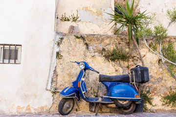blue old scooter parked by the wall in the empty street Chania Crete