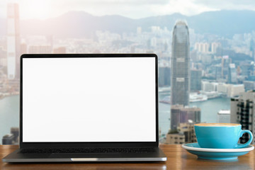 Blank screen Laptop computer and cup coffee with hongkong city background