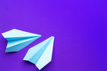 white paper airplane on a purple background