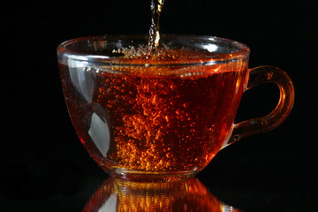 Tea pouring into a glass cup