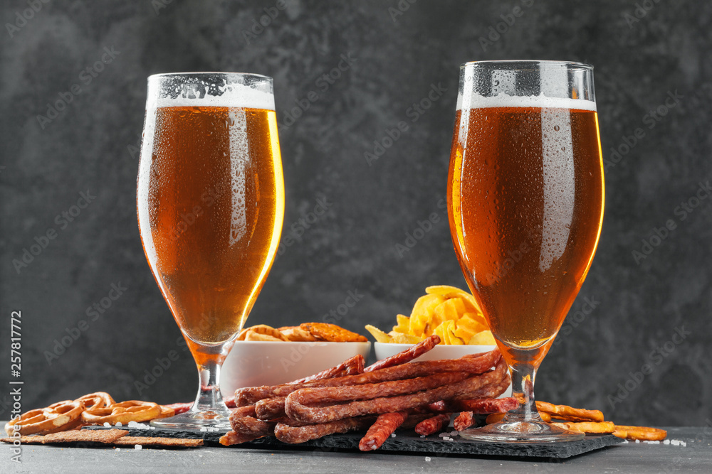 Wall mural beer and appetizing beer snacks set. table with mug of beer, wooden board with sausages