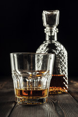 Whiskey glass and bottle on the old wooden table