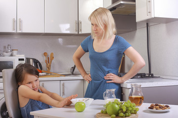  in the kitchen. mother scolding a child. a child refuses to eat, mom makes daughter eat healthy....