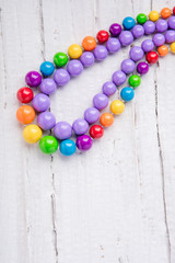 Colorful beautiful bright beads necklace on a wooden background by summer
