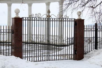 Image of a Beautiful decorative cast iron wrought fence with artistic forging. Winter.