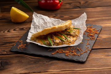 Bao with lamb on black board on wooden background