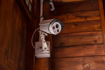 Security CCTV camera surveillance system outdoor of house. A blurred night city scape background. Modern CCTV camera on a wall. Equipment system service for safety life or asset.