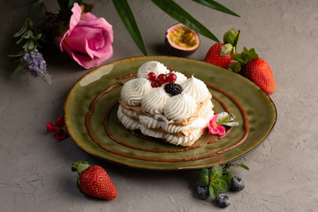 Cake with whipped cream and berries on a green plate