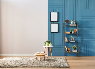 Room wall, blue and white background, wooden coffee table, frame and bookshelf with carpet.
