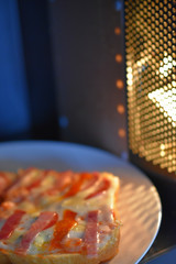 sandwiches with cheese and sausage on a plate in the microwave inside view