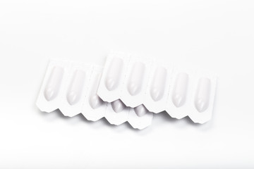 plastic packs of suppositories on white  background