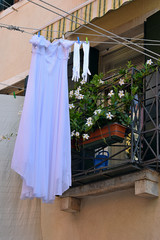 wedding dress and gloves are dried on a rope on the street of Venice