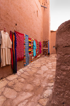 Alley with clothing and fabric shops in the ancient village of Ait Benhaddou in Morocco