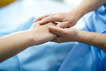 Holding hands Asian senior or elderly old lady woman patient with love, care, encourage and empathy at nursing hospital ward : healthy strong medical concept 