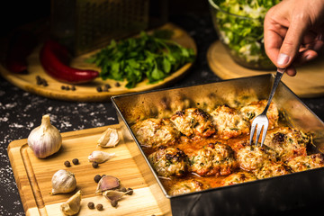 Meatballs in tomato sauce on a baking sheet.