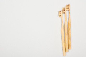 natural bamboo toothbrushes on grey background with copy space