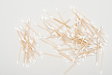 top view of scattered cotton swabs on grey background