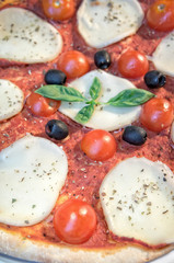 Caprese pizza with fresh cherry tomatoes closeup