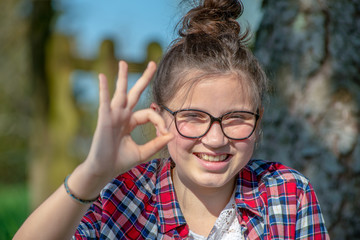 young teenage girl making OK sign