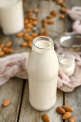Obraz na płótnie Canvas Bottle of tasty almond milk on wooden table