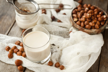 Obraz na płótnie Canvas Glass of tasty hazelnut milk on table