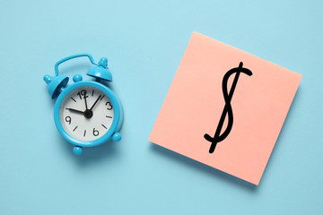 Blue alarm clock and paper reminder. Time management, priorities, efficiency, control and goals.