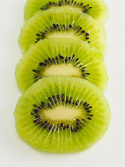 Sliced ​​kiwi fruit on white background, close-up photo of a kiwi, raw green fruit.