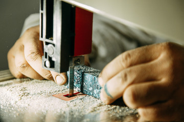 Cutting parts made of wood on the bandsaw. Wood processing workshop.