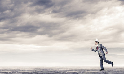 King businessman in elegant suit running and blue sky at background