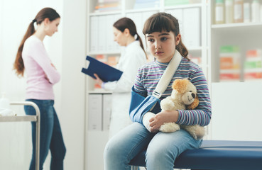 Cute girl with arm brace in the doctor's office